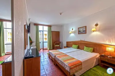 a hotel room with a bed and a television at Colina do Mar in Albufeira