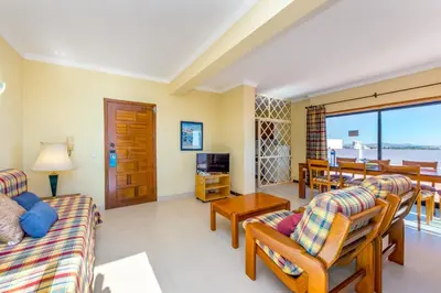 a living room with a couch and chairs and a table at Janelas do Mar Apartamentos Turisticos in Albufeira