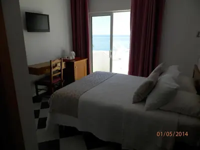 a hotel room with a bed and a window at Frentomar in Albufeira