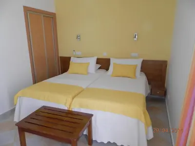 two beds in a room with yellow pillows at Frentomar in Albufeira