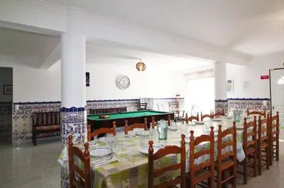 a dining room with a table and a pool table at Quinta Das Flores, Lote 9 in Albufeira
