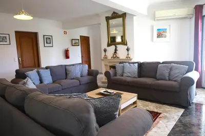 a living room with two couches and a table at Quinta Das Flores, Lote 9 in Albufeira