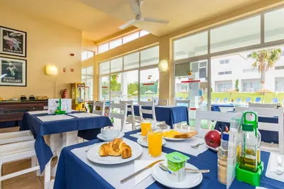 a dining room with blue tables with food and drinks at Pateo Village in Albufeira