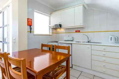 a kitchen with a wooden table and a sink at Club Ouratlantico in Albufeira