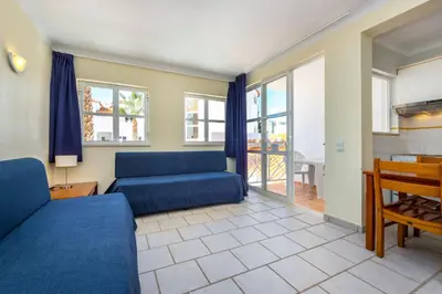 a living room with two blue couches and a table at Club Ouratlantico in Albufeira
