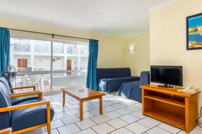 a living room with a couch and a tv at Club Ouratlantico in Albufeira