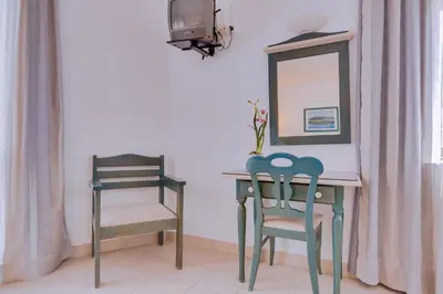 two chairs and a table with a mirror and a table with a mirror at Hotel Mar A Vista in Albufeira