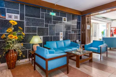 a lobby with blue chairs and a table at Hotel Mar A Vista in Albufeira