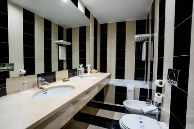 a bathroom with two sinks and a toilet at Boa Vista Hotel & Spa - Adults Only in Albufeira