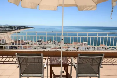 a table and chairs on a balcony with an umbrella at Boa Vista Hotel & Spa - Adults Only in Albufeira