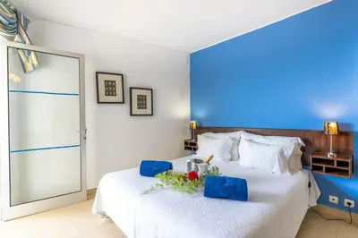 a bedroom with a large white bed with a blue wall at Boa Vista Hotel & Spa - Adults Only in Albufeira