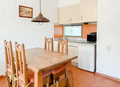 a kitchen with a wooden table and chairs in a room at Oleandro Country Club in Albufeira