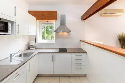 a white kitchen with a sink and a window at Apartamentos Turisticos Pinhal Da Marina in Vilamoura