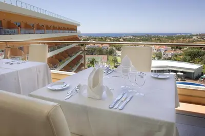 a white table with glasses and napkins on a balcony at Hotel Apartamento Balaia Atlantico in Albufeira