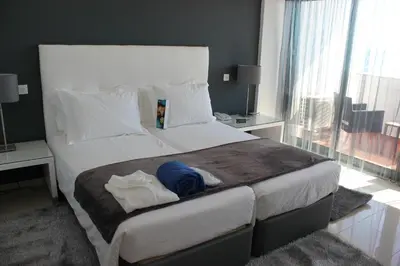 a bedroom with a large bed and a large window at Rocamar Exclusive Hotel & Spa - Adults Only in Albufeira