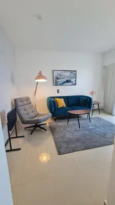 a living room with a blue couch and two chairs at Rocamar Exclusive Hotel & Spa - Adults Only in Albufeira