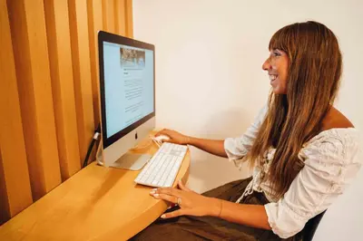 a woman sitting at a desk with a computer at Stay Hotel Faro Centro in Faro