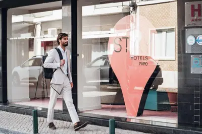 a man walking past a store window with a store sign at Stay Hotel Faro Centro in Faro