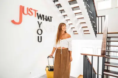 a woman standing next to a staircase with a suitcase at Stay Hotel Faro Centro in Faro