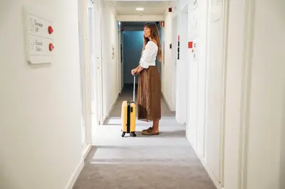 a woman standing in a hallway with a suitcase at Stay Hotel Faro Centro in Faro