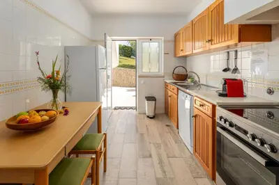 a kitchen with a bowl of fruit on a wooden table at Parque Monte Verde in Albufeira