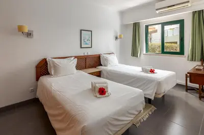 two beds in a hotel room with flowers on them at Parque Monte Verde in Albufeira