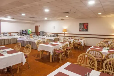 a dining room with tables and chairs with white tablecloths at Best Western Hotel Dom Bernardo in Faro