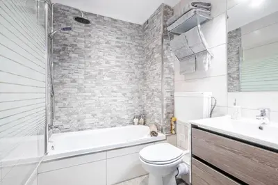 a bathroom with a tub and a toilet and a sink at My Place @ Faro City Views in Faro