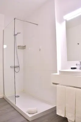 a glass shower in a bathroom with a sink at Hotel Sol Algarve by Kavia in Faro