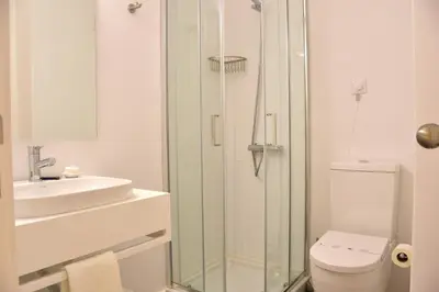 a bathroom with a shower and a toilet and a sink at Hotel Sol Algarve by Kavia in Faro