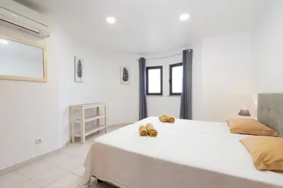 a white bedroom with a large bed with two teddy bears on it at Apartamentos Vale de Carros by Umbral in Albufeira