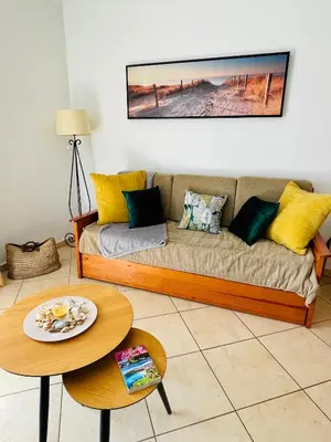 a living room with a couch and a table at Seashell Apartment OURA in Albufeira