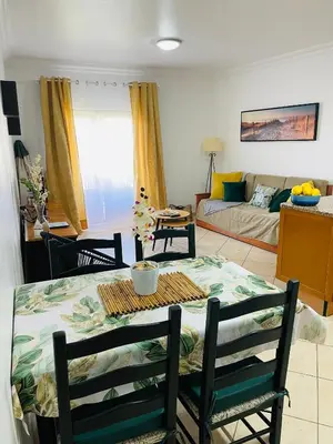 a living room with a table and a couch at Seashell Apartment OURA in Albufeira