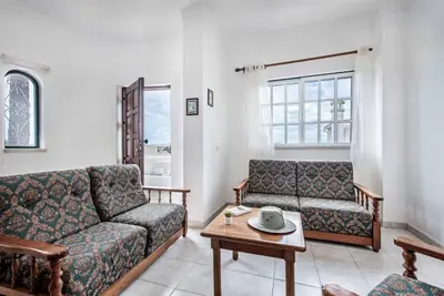a living room with two couches and a table at Villa Torcato in Albufeira