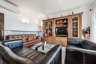 a living room with leather furniture and a tv at Villa Torcato in Albufeira