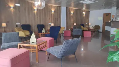 a waiting room with chairs and tables in a hospital at Hotel Alnacir in Faro