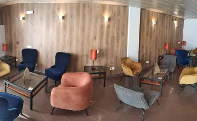 a waiting room with chairs and tables at Hotel Alnacir in Faro