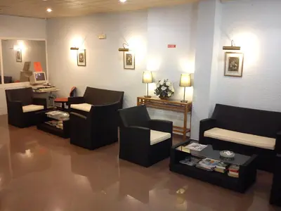 a waiting room with couches and a table and a desk at Hotel Alnacir in Faro