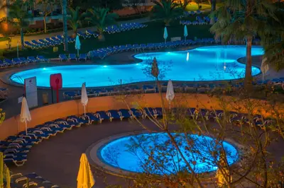 a couple of swimming pools with umbrellas and chairs at 3HB Clube Humbria - All Inclusive in Albufeira