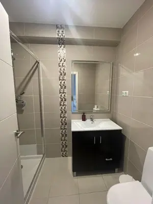 a bathroom with a toilet and an orange shower curtain at Apartamentos Carteia in Quarteira