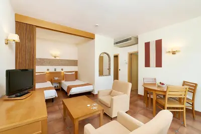 a living room with a couch and a television at Oceanus Aparthotel in Albufeira