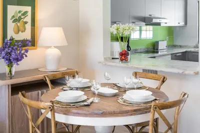 a dining room table with chairs and a table with wine glasses at Clube Albufeira Garden Village in Albufeira
