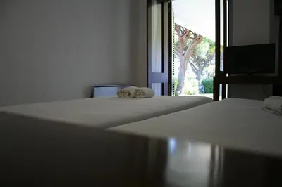 two beds with towels on them in a room with a window at Aldeia Da Falesia in Albufeira