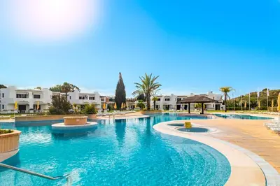 a swimming pool with blue water in a resort at 60m2 Lovely traditional apartment in Clube Albufeira in Albufeira