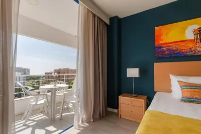 a bedroom with a bed and a table and a balcony at The Navigator - Olympus Marina in Vilamoura
