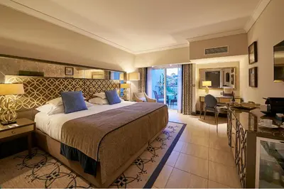 a hotel room with a large bed and a desk at Dona Filipa Hotel in Vale do Lobo