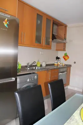 a kitchen with brown cabinets and a table and chairs at Sweet Dream House in Faro