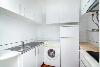 a white kitchen with a washing machine and a sink at WHome | Albufeira Suite & Beach Apartment in Albufeira
