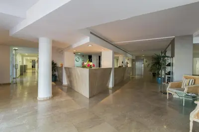 a patio with chairs and a swimming pool on a building at Hotel Quarteirasol in Quarteira