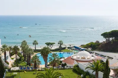 a living room with a desk and a red couch at Grand Muthu Oura View Beach Club in Albufeira